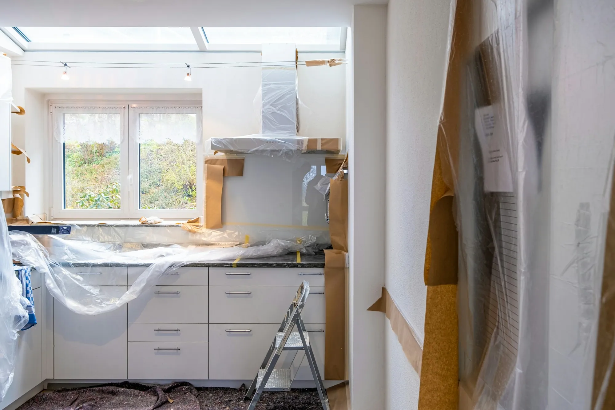 Remodeler fitting a new kitchen cabinet door with a cordless drill